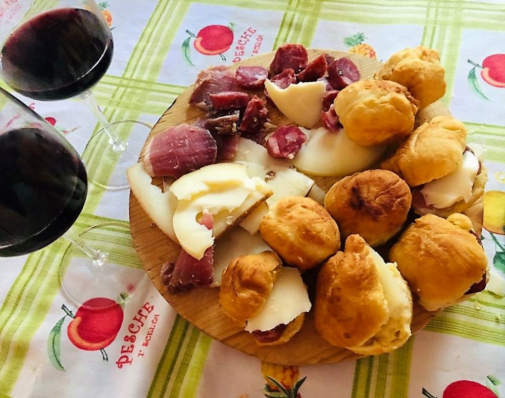Struppoli di San Salvatore accompagnati da salumi, formaggi e vino rosso. Foto di copertina d'archivio